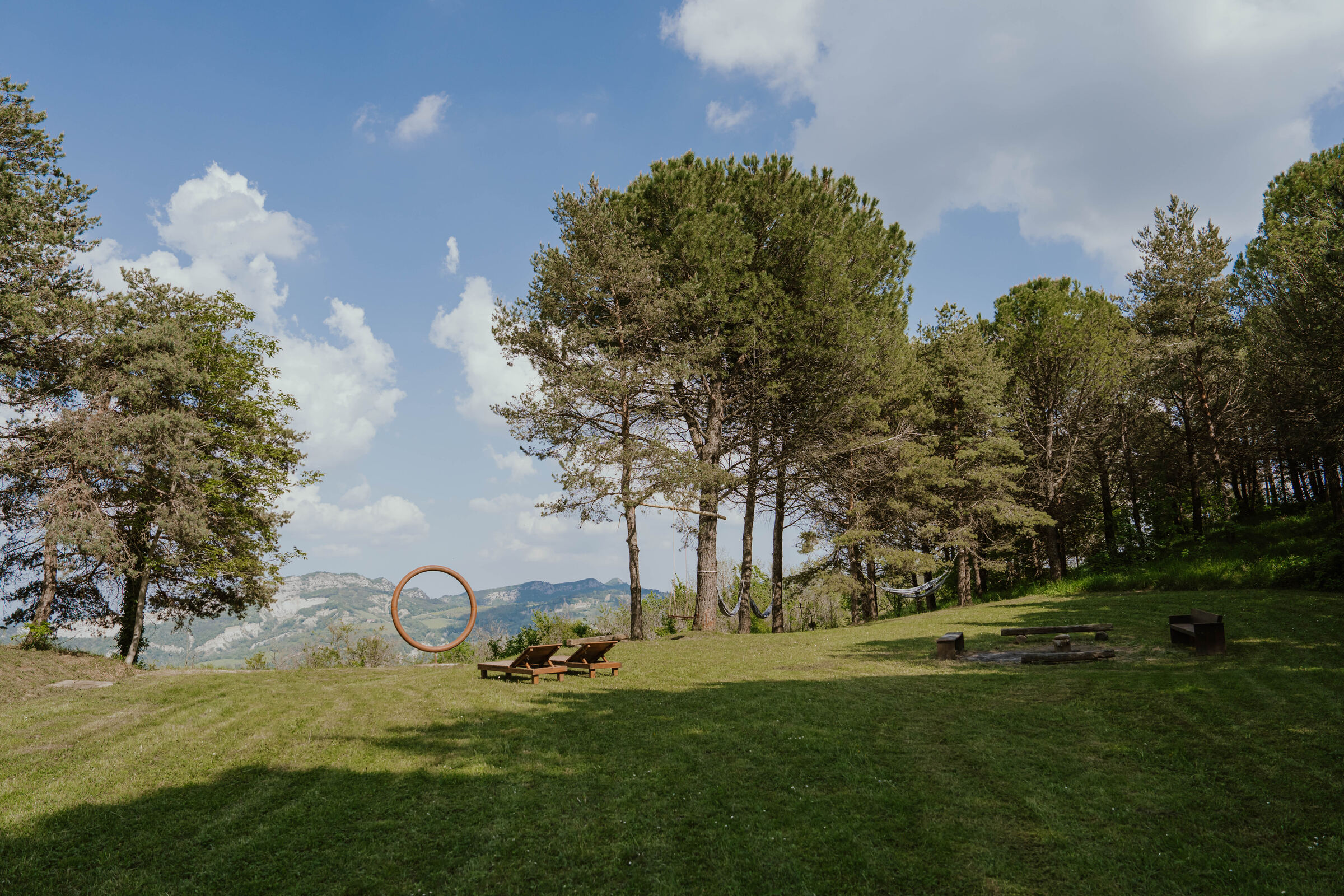The lawn at Vidovina with pine trees, sunbeds and the iron ring